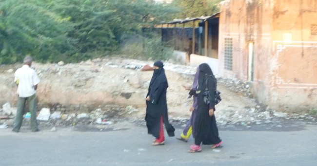 Man peeing in the street with muslim women walking past (we were in a moving van which is why its blurry)