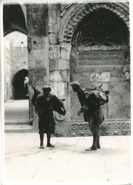 Natives carrying water in Pig Skin containers