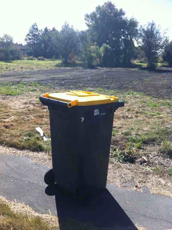 A lone, abandoned recycle bin